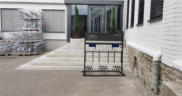 Installation support mobile 5 vélos électriques SCHAKE devant bâtiment, solution de stationnement modulable avec recharge intégrée
